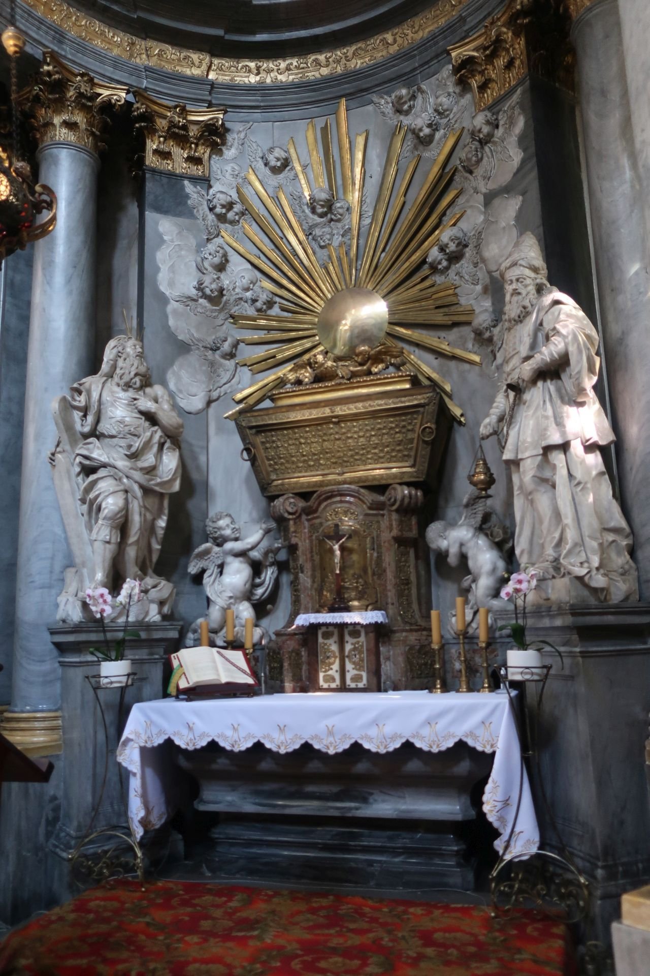 Kaplica elektorska przy katedrze na Ostrowie Tumskim. 2.	Na ołtarzu złoconą skrzynię Arki Przymierza wieńczy lśniące słońce ? symbol Chrystusa. Obok fenomenalne rzeźby Ferdynanda Maksymiliana Brokoffa, ukazujące Mojżesza i Aarona
