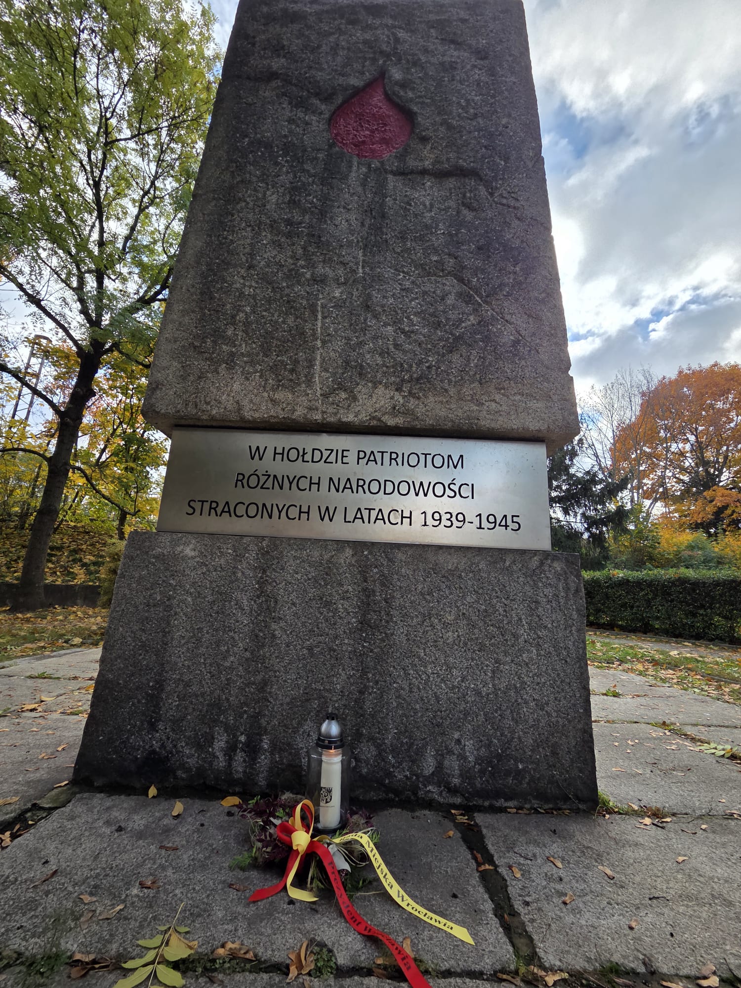 Złożenie kwiatów przy zbiorowych miejscach pamięci