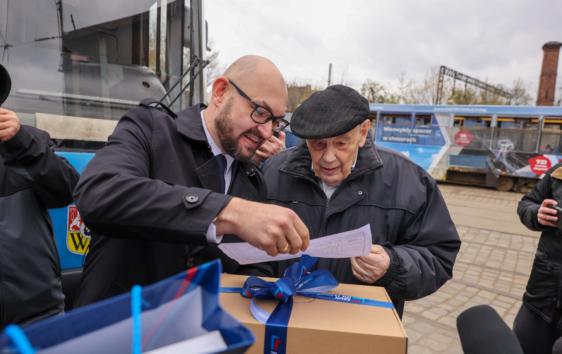 Roman Kroczak w dniu swoich setnych urodzin prowadził tramwaj na zajezdni Ołbin. Prezes MPK Witold Woźny składa życzenia i wręcza upominki