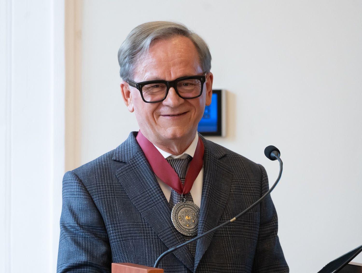 Uhonorowany Grzegorz Dzik. Zdjęcie mężczyzny, na którego szyi wisi medal.