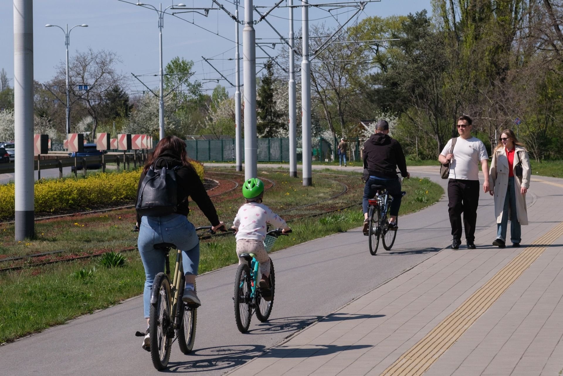 Powiększ obraz: Rowerzyści na drodze rowerowej we Wrocławiu. Na pierwszym planie mama z dzieckiem