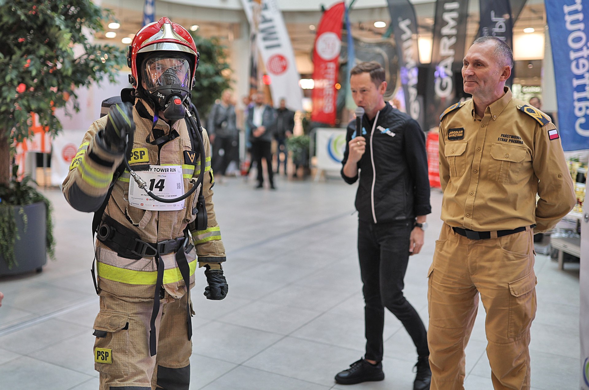 Powiększ obraz: Strażak w żółtym kombinezonie, kasku ochronnym i masce tlenowej. W biegu na szczyt Sky Tower startują także strażacy w pełnym rynsztunku.