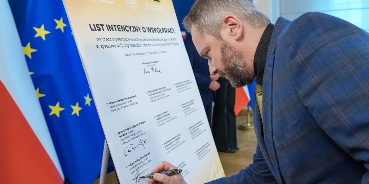 Podpisanie listu intencyjnego w sprawie powołania Dolnośląskiego Akademickiego Korpusu Ochrony Ludności (DAKOL). Wrocław, 21.07.2026. Podpis składa prof. Kamil Staniec, prorektor ds. kształcenia PWr.