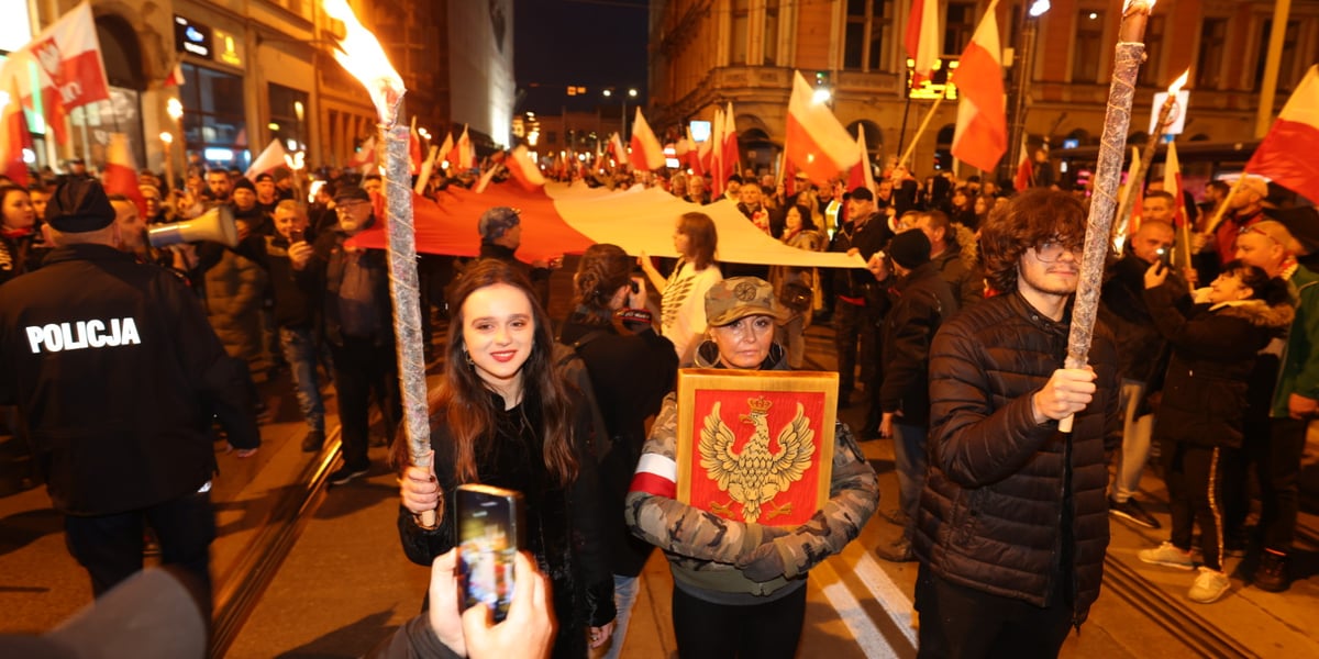 Na zdjęciu grupa demonstrantów z flagami podczas marszu narodowców