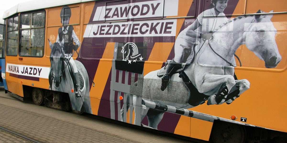 Na zdjęciu: wagon tramwajowy z grafiką pokazującą dwójkę jeźdźców - dziecko i kobietę - na koniach