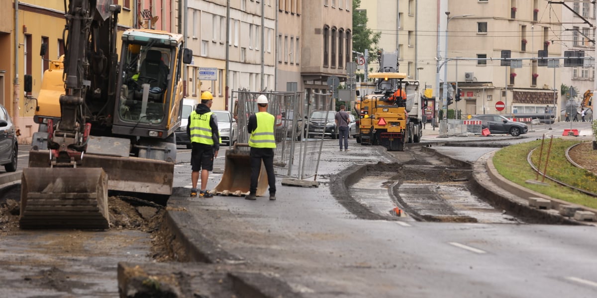 Rozkopana jezdnia, koparka i dwójka robotników w żółtych kamizelkach; ulica Kazimierza Wielkiego