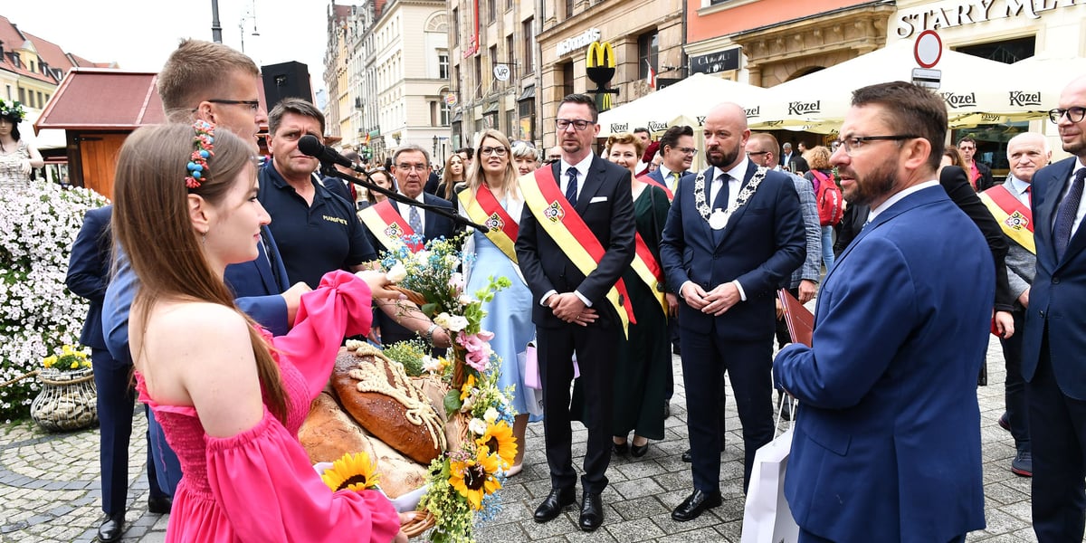 Jacek Sutryk (prezydent) i Sergiusz Kmiecik (przewodniczący rady miejskiej) odbierają bukiet kwiatów na rynku podczas Święta Wrocławia