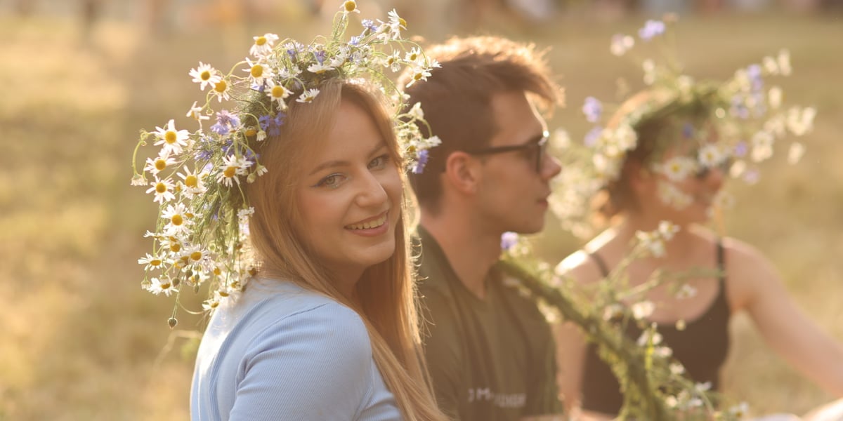 Noc Świętojańska w OPT Zamek. Piękna blondynka w wianku z kwiatów na pierwszym planie