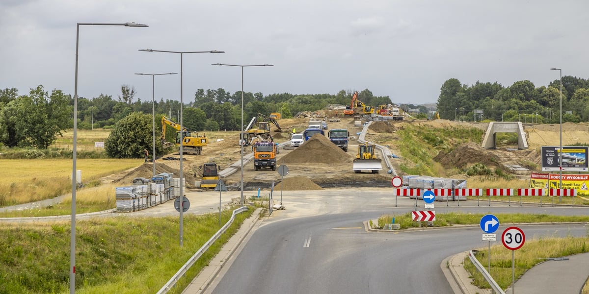 Koparki, spycharki i inne pojazdy budowlane na przygotowywanym wjeździe na wiadukt na trasie powstającego odcinka obwodnicy Leśnicy