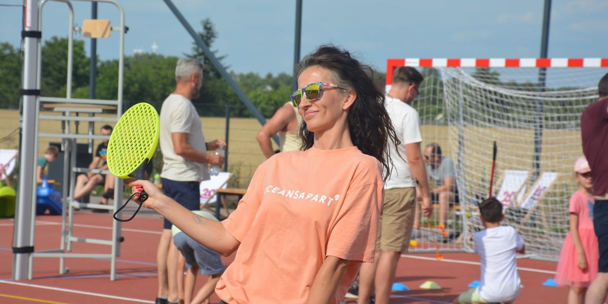 Czarnowłosa kobieta w okularach słonecznych i z żółtą paletką