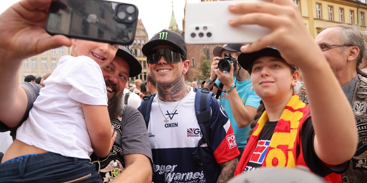 Kibice i Tai Woffinden w okularach słonecznych w trakcie robienia wspólnego zdjęcia