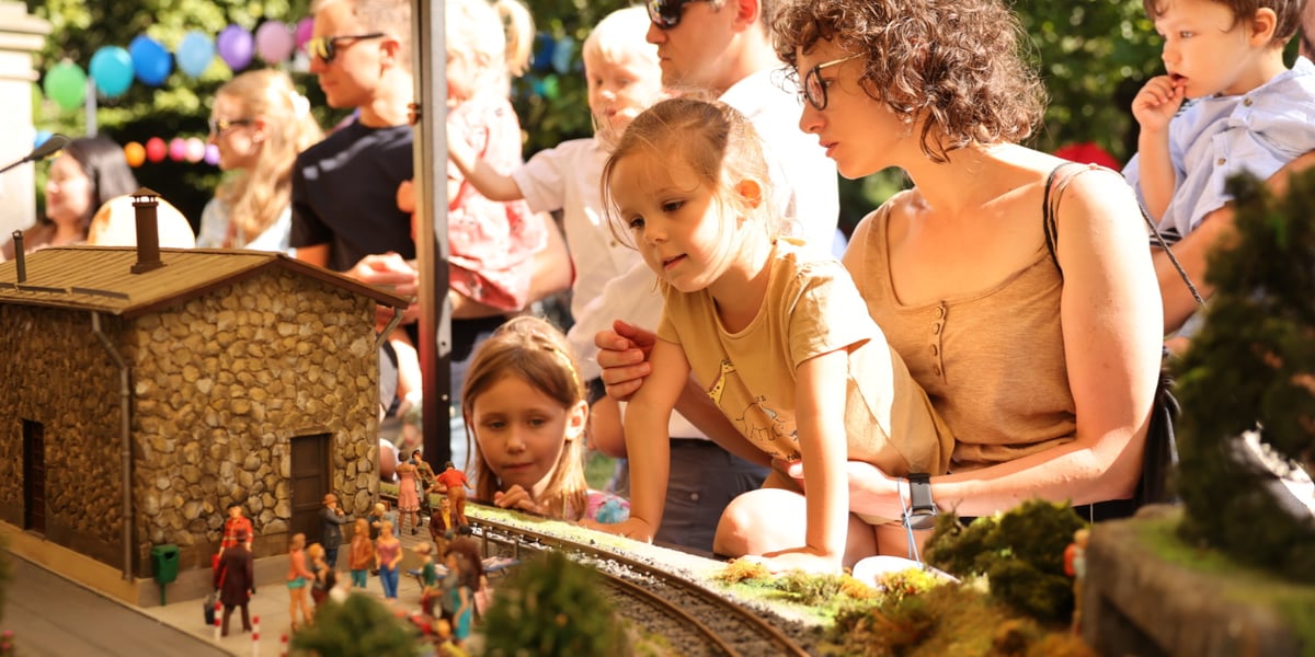 Dzieci i rodzice przy makiecie z figurkami w parku Staromiejskim. Wrocławski Festiwal Krasnoludków.