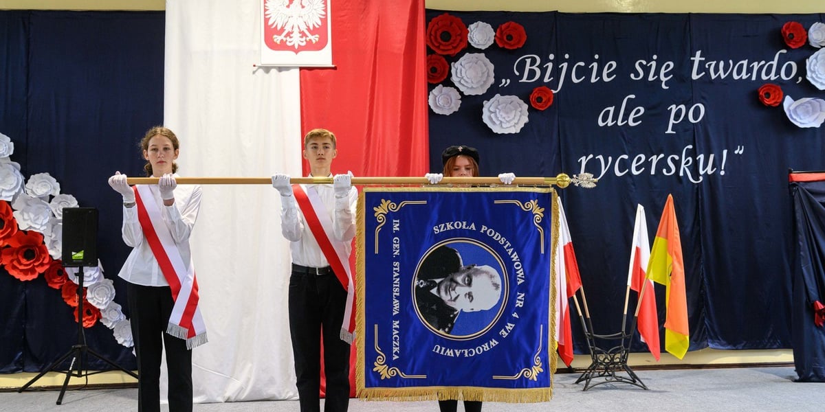 Uczniowie ze sztandarem szkoły, na którym jest wizerunek nowego patrona, generała Stanisława Maczka