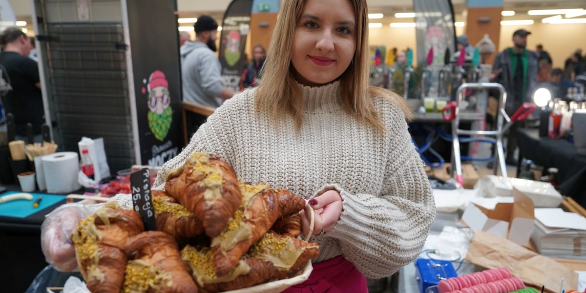 Młoda kobieta na jednym ze stoisk festiwalu kulinarnego w Hali IASE z rogalami.