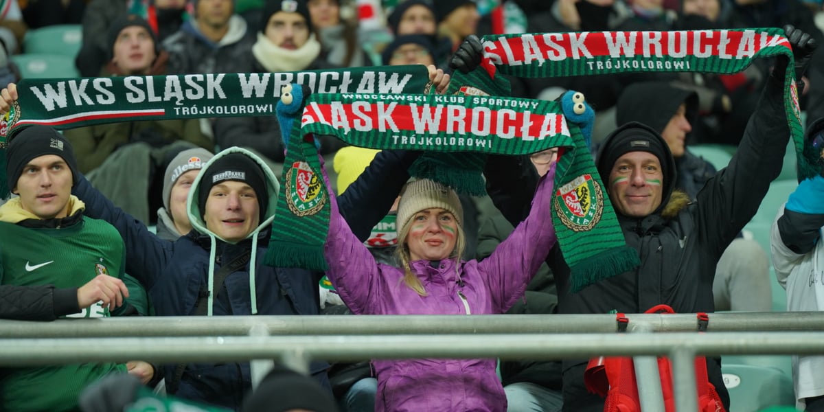 Mecz Śląsk Wrocław kontra Raków Częstochowa. Na zdjęciu kibice, którzy siedzą na trybunach i trzymają w rękach szaliki WKS-u