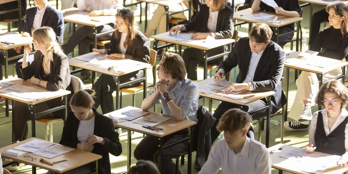 Matura 2023 w VII LO we Wrocławiu. Uczniowie siedzą w ławkach i rozwiązują test