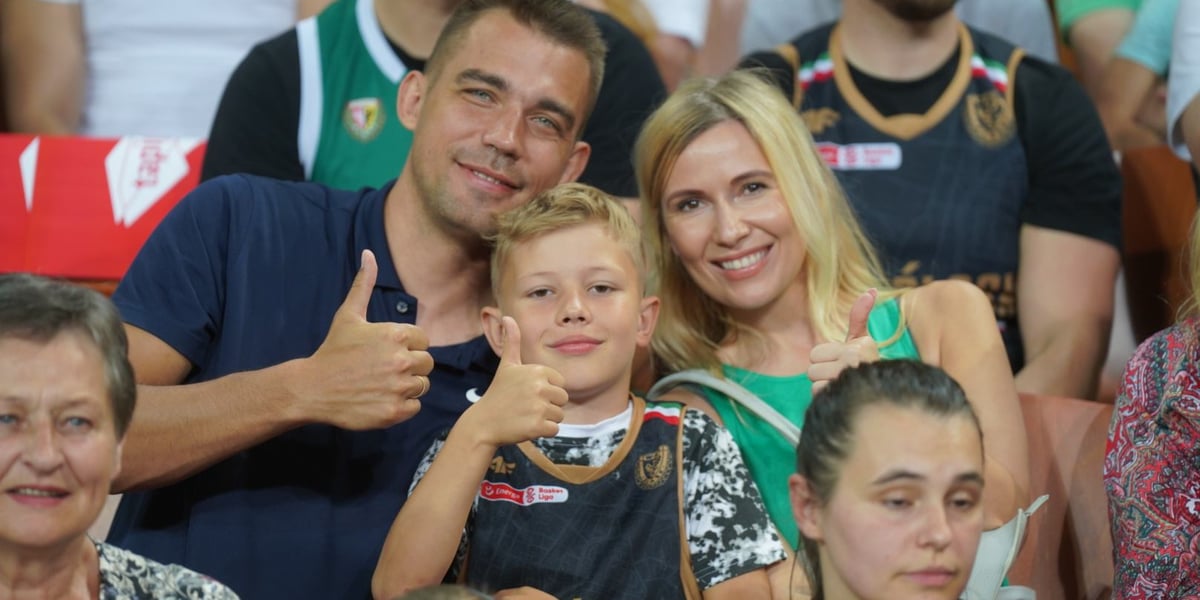 Uśmiechnięci kibice w Hali Stulecia na meczu z Treflem: kobieta, mężczyzna i chłopiec