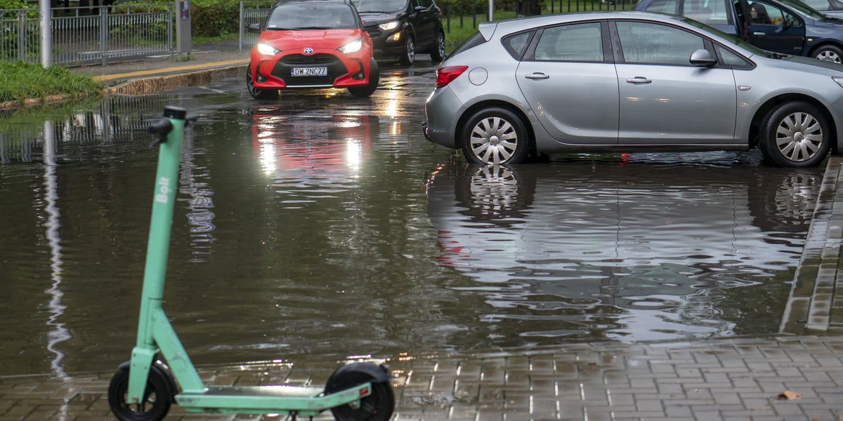 Ulewa we Wrocławiu. Samochody przejeżdżający przez zalaną ulicę, hulajnoga w kałuży