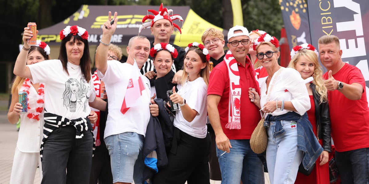 Żużel na Olimpijskim. Na zdjęciu kibice - kobiety i mężczyźni, mają czapki, wianki i szaliki w biało- czerwonych barwach