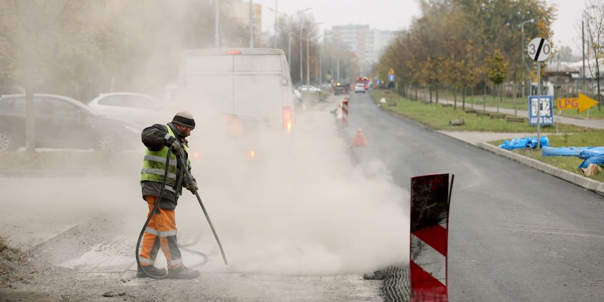 Osoba w roboczym stroju z dymiącym urządzeniem na remontowanej ulicy Balonowej
