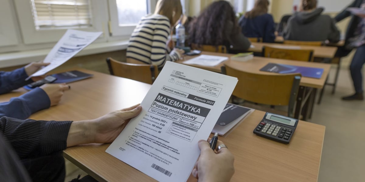 Matura próbna z matematyki z CKE w XV LO we Wrocławiu. Na pierwszym planie arkusz egzaminacyjny i dłonie. Zdjęcie archiwalne