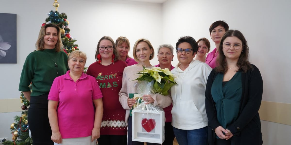 Na zdjęciu Anna Wyszkoni (w kremowym swetrze) z pracownikami i seniorami Dziennego Domu Pomocy w Leśnicy, w białej bluzie kierowniczka Agnieszka Pieniążczak
