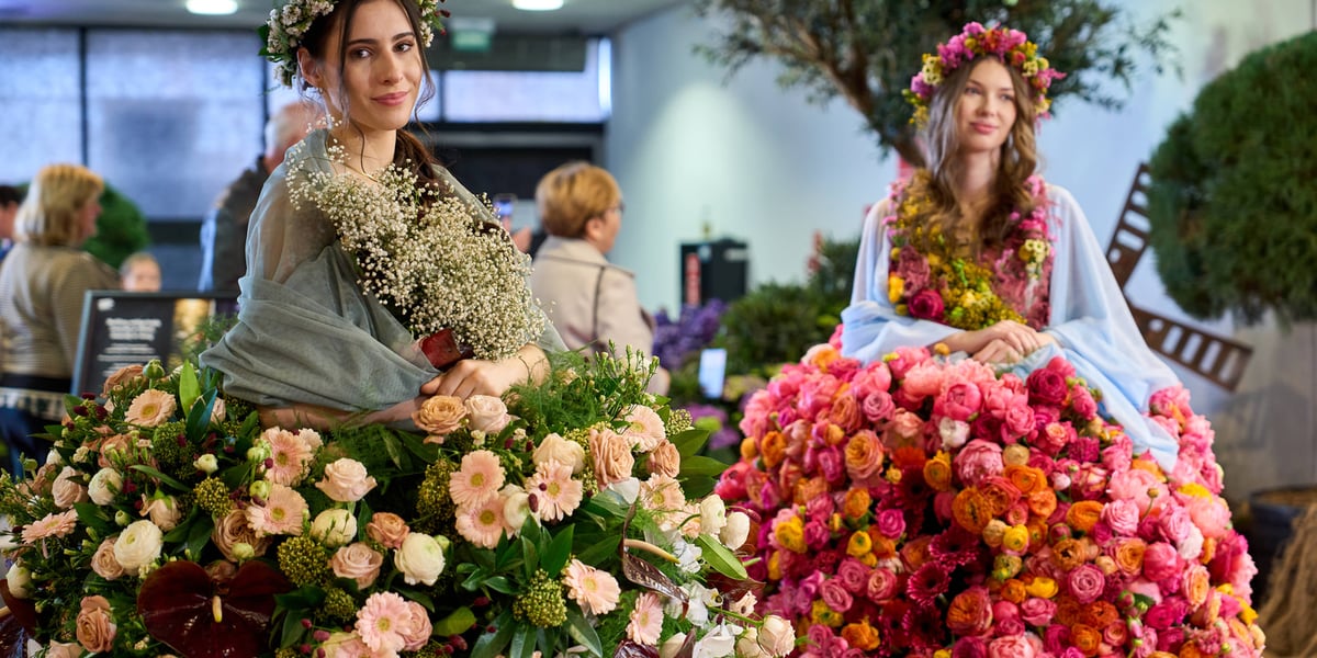 Na zdjęciu dwie kobiety w kwietnych sukniach podczas World Flower Show we Wrocławiu