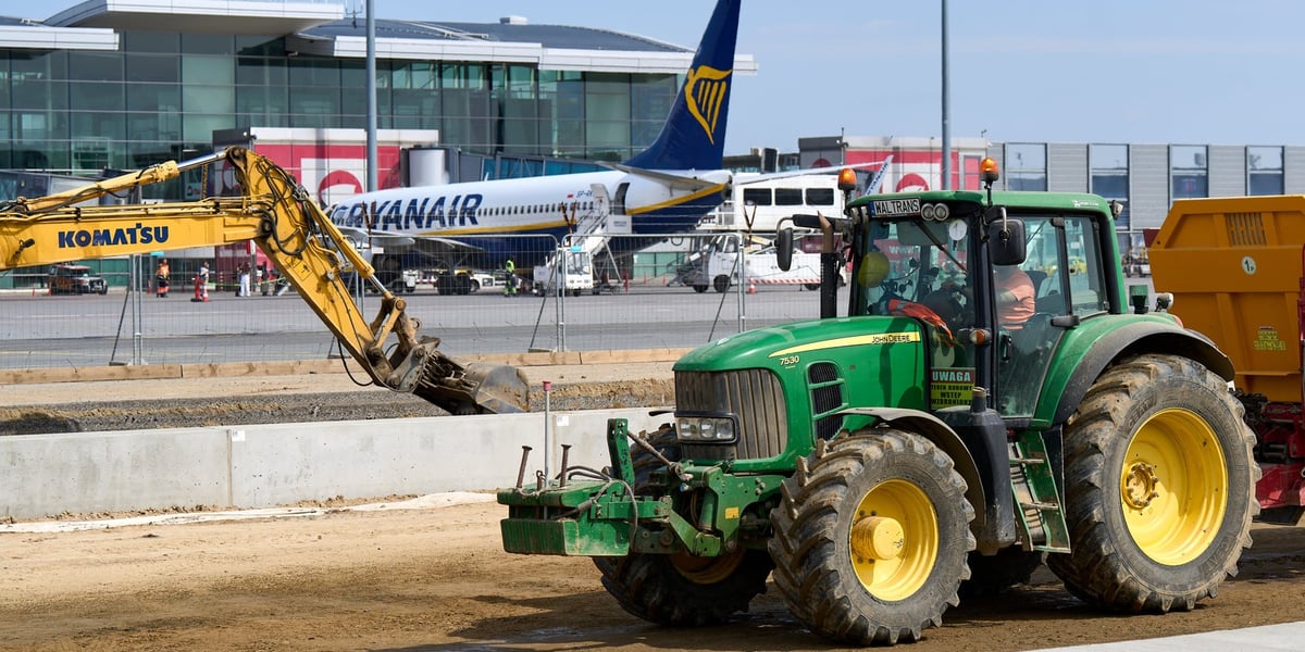 Rozbudowa wrocławskiego lotniska. Na pierwszym planie maszyny, w tle samolot i terminal 