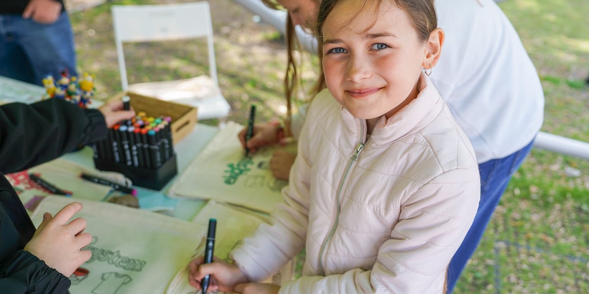 Festyn „Dbam to mam” na Starym Mieście - 21.04.2026 r. - dziewczynka pozuje z pomalowaną na festynie torbą