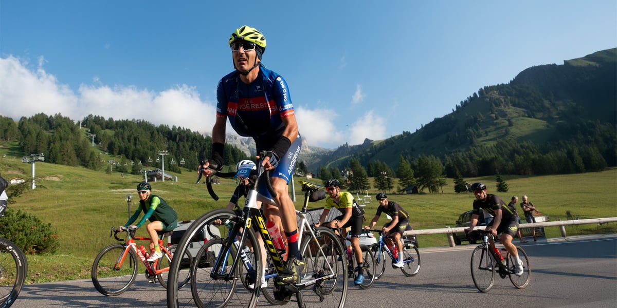 Na zdjęciu grupa rowerzystów w strojach sportowych