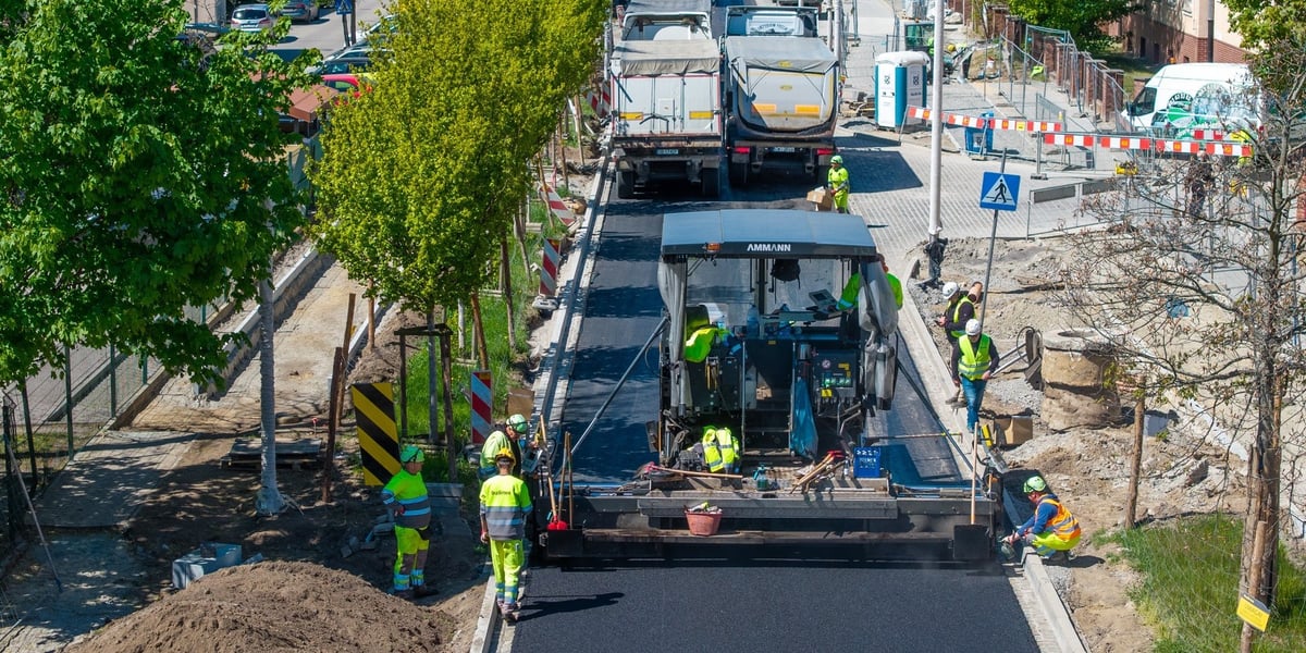 Kładzenie masy bitumicznej na ulicy Koszarowej 