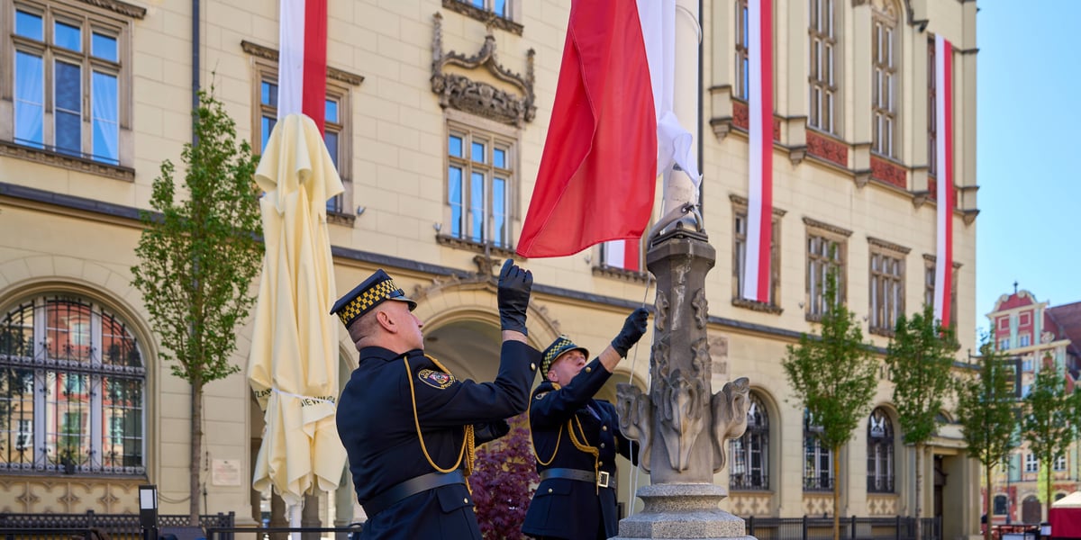 Żołnierz wciąga na maszt flagę Polski na wrocławskim Rynku