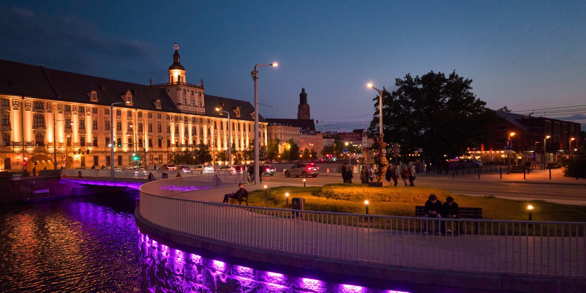 Most Uniwersytecki we Wrocławiu podświetlony z okazji Światowego Dnia Nieswoistego Zapalenia Jelit. Na zdjęciu most, w tle budynek Uniwersytetu Wrocławskiego