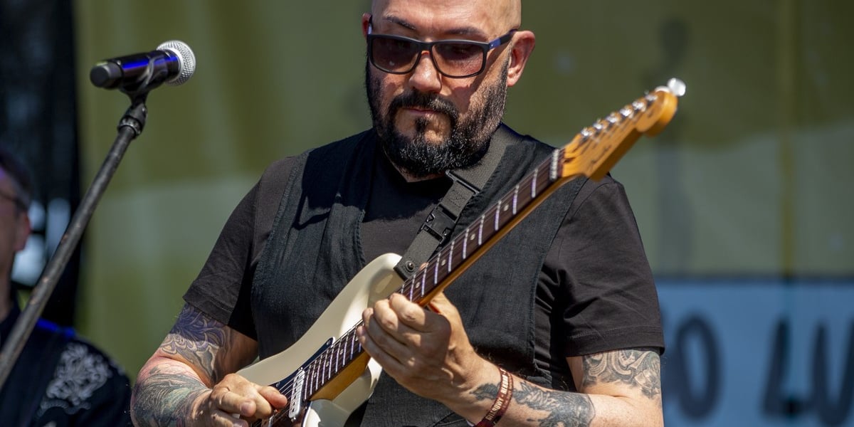 Grzegorz Skawiński, lider zespołu Kombii. Na zdjęciu mężczyzna gra na gitarze