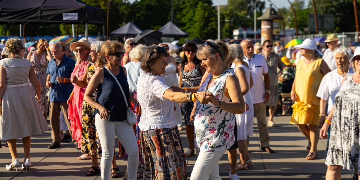 Potańcówka na placu przed CH Zajezdnia. Na pierwszym planie dwie tańczące kobiety.