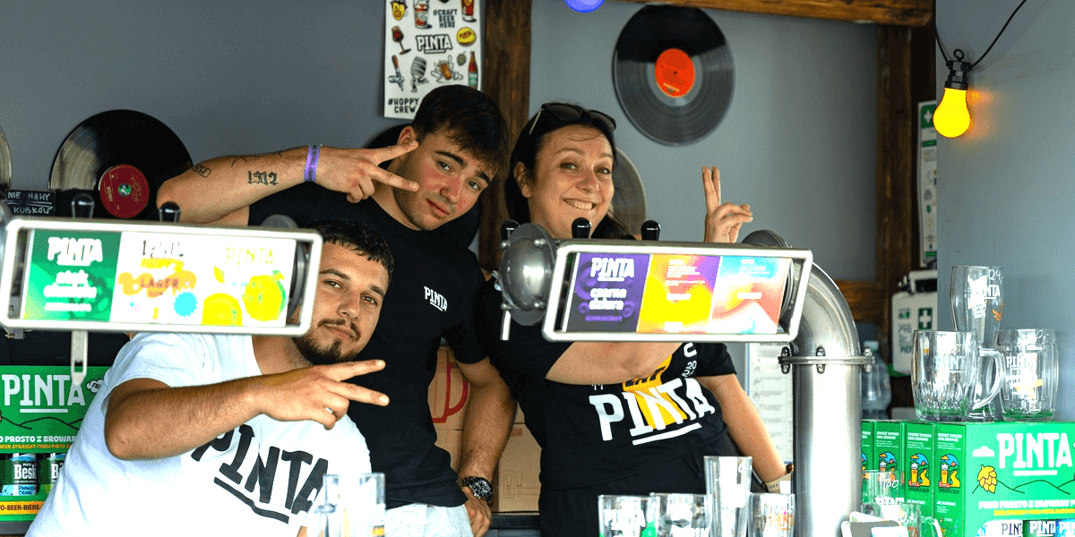 Wrocławski Festiwal Dobrego Piwa na Tarczyński Arenie - 20 czerwca 2026 r. Na zdjęciu trzy osoby pozuje do zdjęcia na jednym ze stoisk Festiwalu 