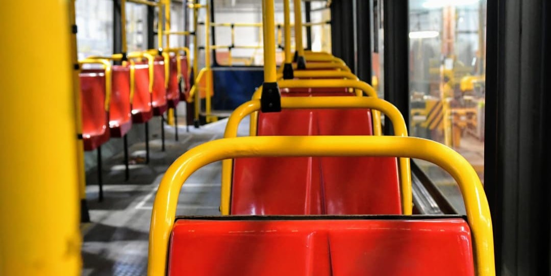 Stare, plastikowe czerwone siedzenia w tramwaju Konstal 105 
