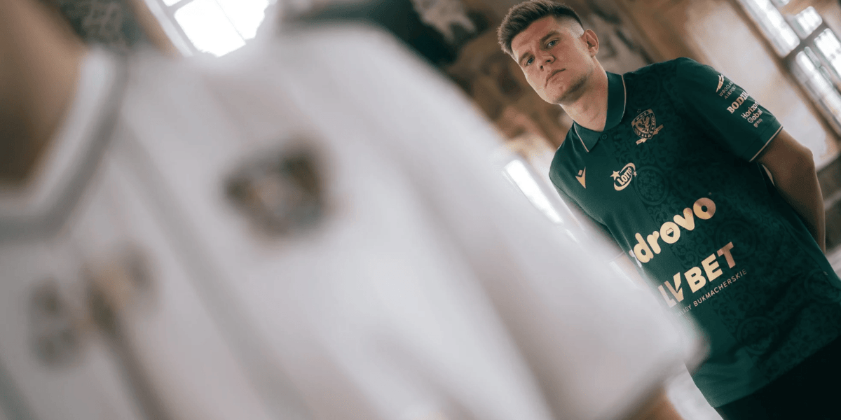 Widać fragment biało-beżowej koszulki Śląska, w tle Piotr Samiec-Talar w zielonej