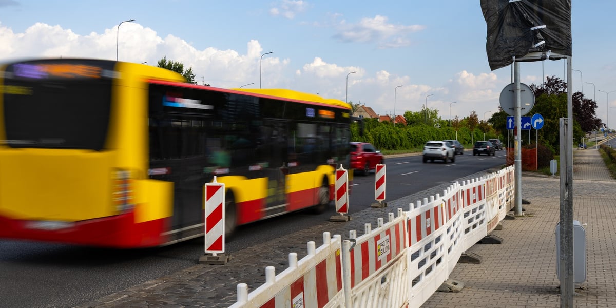 Wyłączony z ruchu przystanek z zasłoniętą tablicą i płotkami oddzielającymi od zatoki przy ul. Klecińskiej. Jezdnią przejeżdża autobus komunikacji miejskiej.