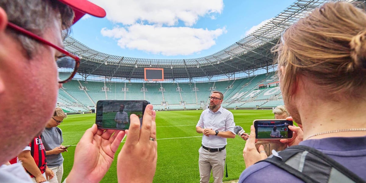 Kilka osób na płycie Tarczyński Areny, 12 sierpnia 2026. W środku Marcin Janiszewski, rzecznik prasowy stadionu
