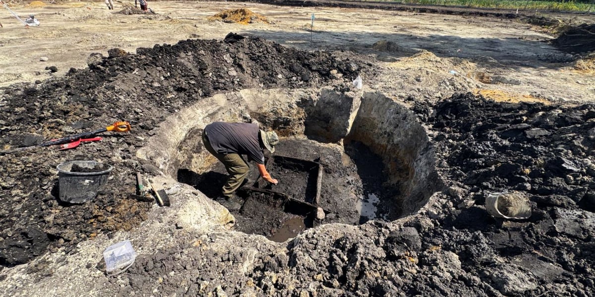 Archeolog w wykopie na terenie budowy przyszłych boisk sportowo-rekreacyjnych w Iwinach.