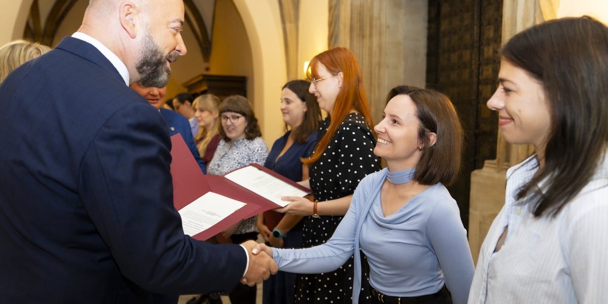 Uroczystość wręczenia aktów na stopień nauczyciela mianowanego we Wrocławiu, 26 sierpnia 2026 z udziałem prezydenta Wrocławia Jacka Sutryka. Na zdjęciu prezydent wręcza dokument uśmiechniętej nauczycielce.
