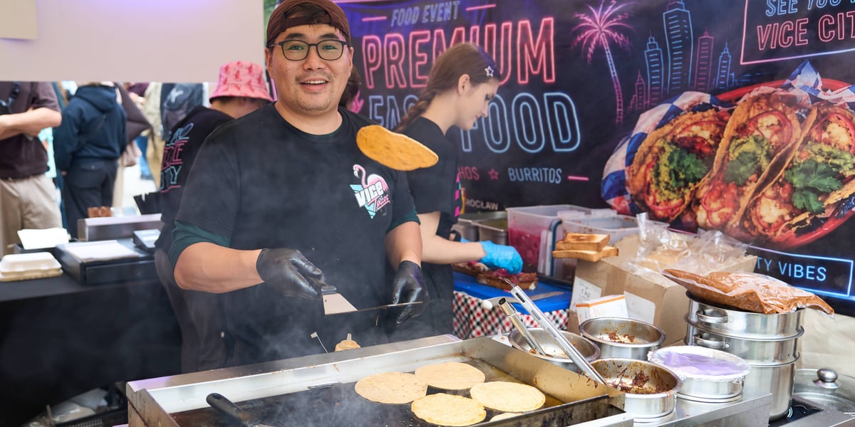 Finałowa edycja Gastro Miasto we Wrocławiu. Na zdjęciu młody uśmiechnięty mężczyzna przy grillu