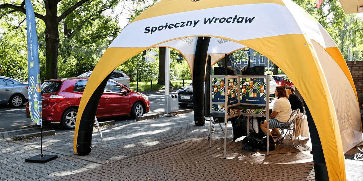 Mobilny punkt umożliwiający potwierdzenie tożsamości i zagłosowanie w WBO 2026. W piątek 18 września punkt zlokalizowany był na Zaciszu, obok siedziby CAL Zacisze i Rady Osiedla Zacisze-Zalesie-Szczytniki.