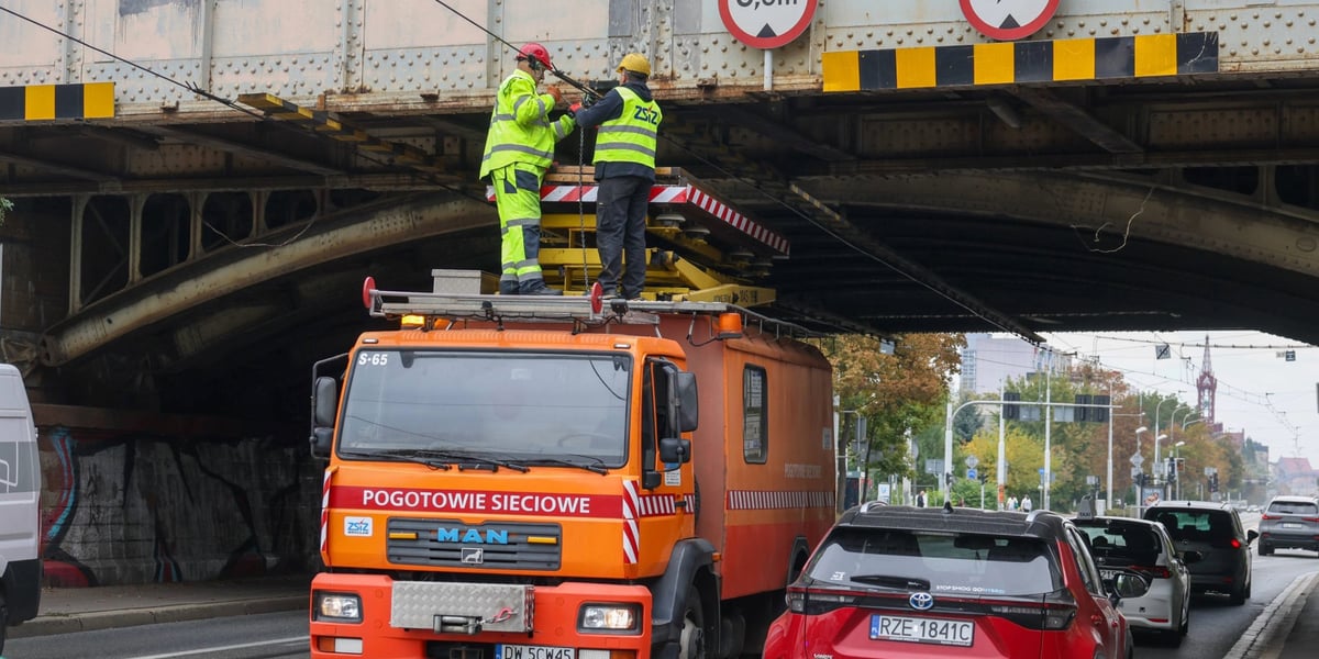 Pracownicy służb na podnośniku naprawiają uszkodzoną trakcję pod wiaduktem kolejowym, 7.10.2026 r.