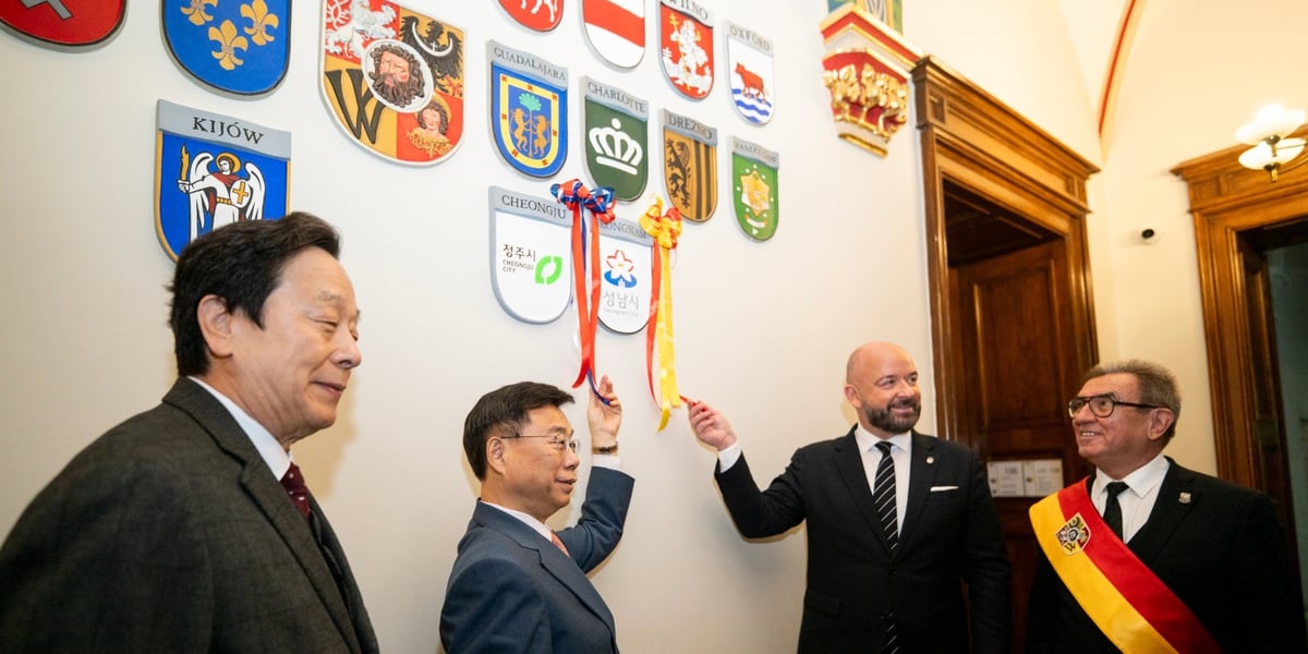 Prezydent Jacek Sutryk i burmistrz Sang-Jin Shin odsłaniają herb miasta Seongnam na ścianie we wrocławskim Ratuszu