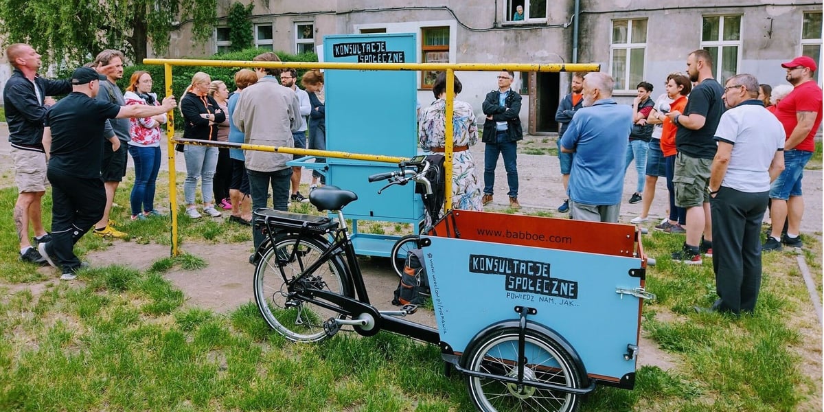 Konsultacje podwórka przy ulicy Struga, 17 maja 2022. Na pierwszym planie wózek konsultacyjny.