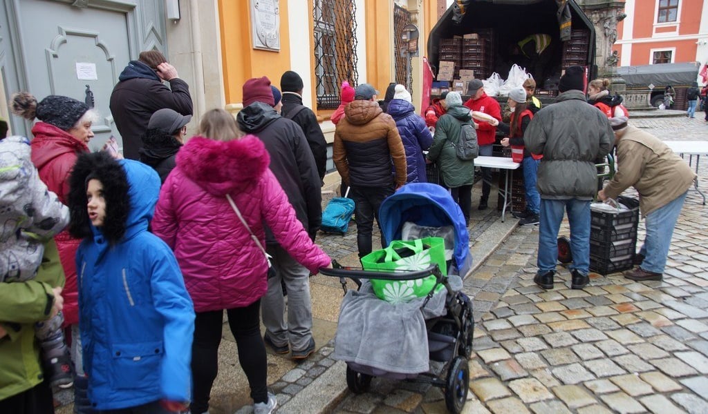 Na zdjęciu widać kolejkę ludzi po świąteczne paczki