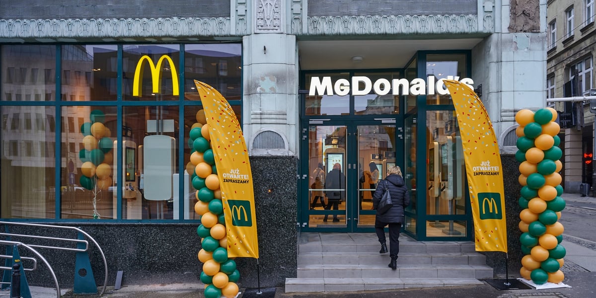 Na zdjęciu kobieta wchodząca do nowo otwartego McDonald'sa przy ul. Ruskiej, w zabytkowym budynku dawnego Domu Towarowego Maxa Goldsteina „Reussenhof” 