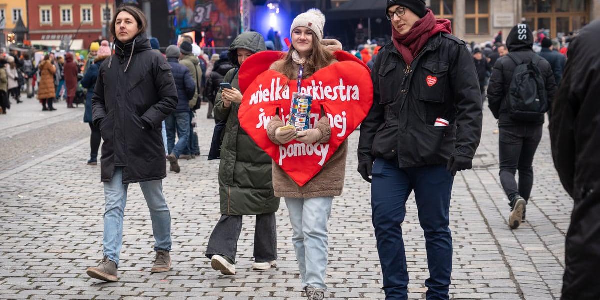 Na zdjęciu koncert WOŚP na wrocławskim Rynku oraz wolontariuszka przebrana za wielkie czerwone serce z napisem "Wielka Orkiestra Świątecznej Pomocy"